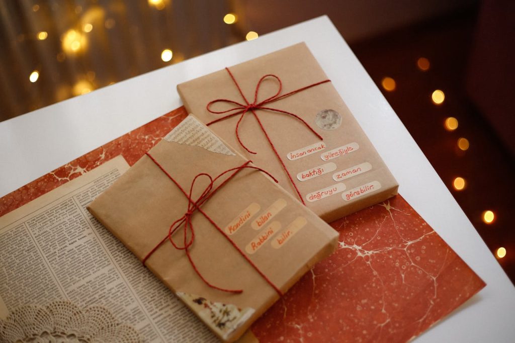 festive-gifts-wrapped-in-brown-paper-with-red-strings-29191784 Charming scene of gifts wrapped in brown paper with red strings, perfect for holiday celebrations.