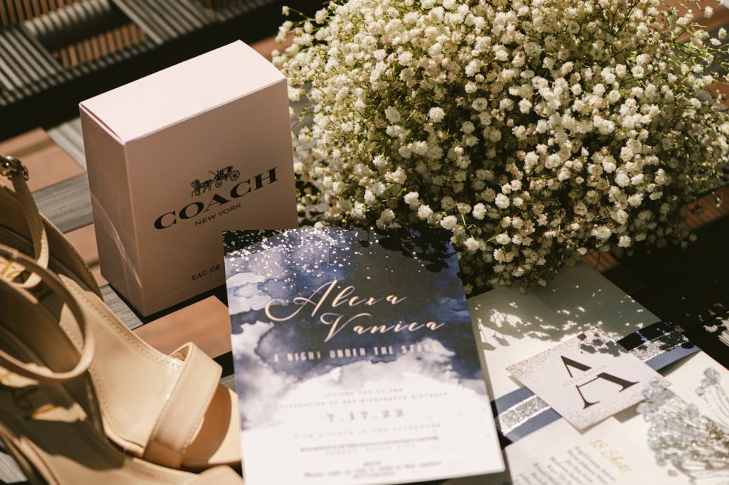 luxurious-brand-items-and-flowers-12891490 A stylish wedding invitation set with shoes, luxury perfume, and flowers.